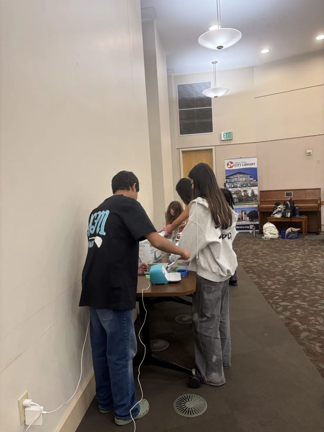 Kids at the hands-on station with a laptop and cutter
